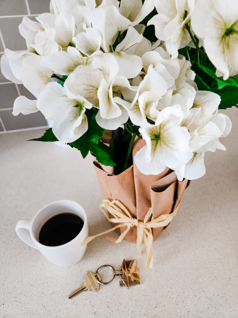 Flowers, a coffee cup and house key on the counter at an Airbnb